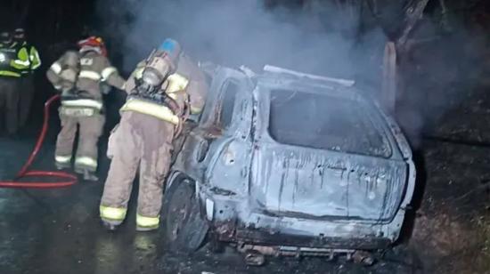 Bombero atiende una emergencia en Loja por un carro incendiado.