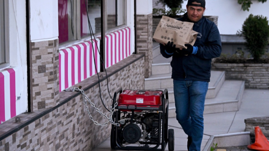 Un hombre camina junto a un generador eléctrico