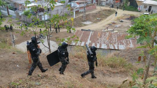 Unidades tácticas de la Policía Nacional durante un operativo de destrucción de casas utilizadas para mantener en cautiverio a personas secuestradas en el distrito Nueva Prosperina, al noroeste de Guayaquil, el 19 de junio de 2024.