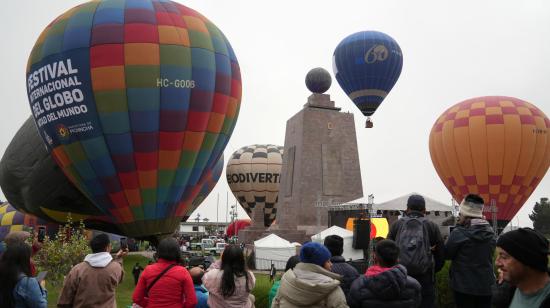 Personas observan globos aerostáticos durante el Festival Internacional del Globo en la Mitad del Mundo, en Quito (Ecuador). Durante el Tercer Festival Internacional del Globo, cientos de asistentes tuvieron la oportunidad de admirar y fotografiar la majestuosidad de los globos, junto con una variada oferta cultural. EFE/ Vicente Costales