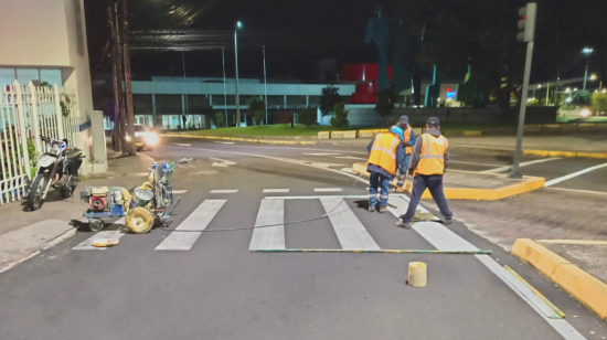 Funcionarios de la Epmmop trabajan en la implementación de la ciclovía en la avenida de La Prensa, en el norte de Quito.