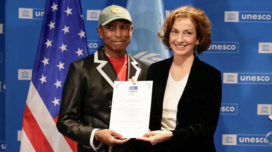 Pharrell Williams muestra su diploma junto a la directora general de la UNESCO, Audrey Azoulay, 17 de diciembre de 2024.