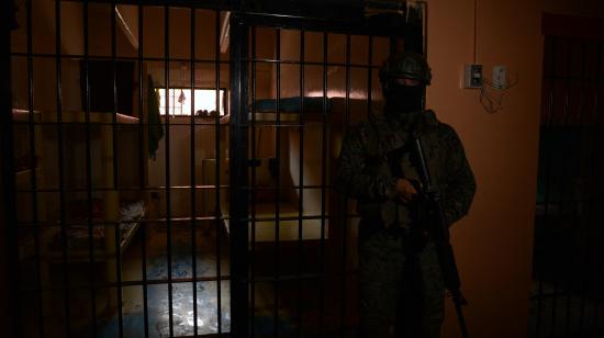 Un soldado apostado en la penumbra del interior del pabellón 3 de la Penitenciaría del Litoral, en el norte de Guayaquil, el 9 de febrero de 2024.