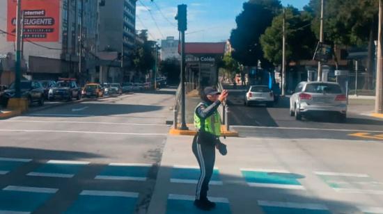 Agente de tránsito gestiona el tráfico ante la falta de luz en la avenida 10 de Agosto, en el norte de Quito.