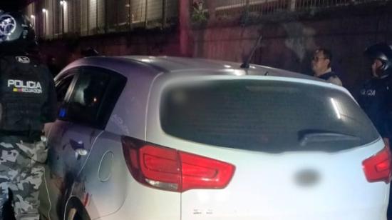 Policía rodean el carro donde se encuentra un presunto delincuente abatido en Manta, en Manabí.