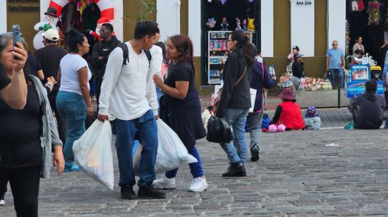 Personas con sus compras navideñas en el centro de Quito, el 21 de diciembre de 2024.