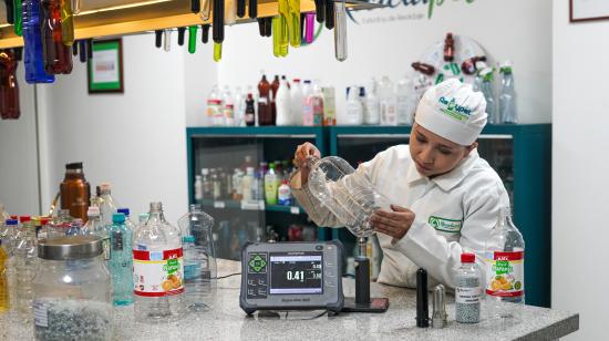 Mujer realizando proceso de reciclaje de botellas plásticas