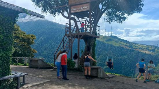 Turistas en la Casa del Árbol, famosa atracción natural de Baños de Agua Santa, en Tungurahua.