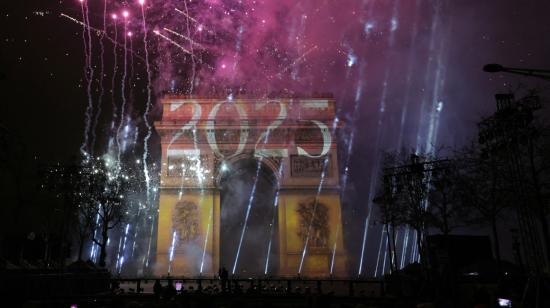 Los fuegos artificiales iluminan el cielo alrededor del Arco del Triunfo en la Avenida de los Campos Elíseos en París, 1 de enero de 2025.