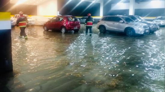 Personal del Cuerpo de Bomberos de Quito atienden la emergencia por acumulación de agua en un parqueadero, por las intensas lluvias de este 7 de enero de 2025.