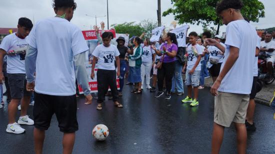 Compañeros de equipo de Ismael Arroyo, uno de los cuatro niños desaparecidos y asesinados tras un operativo militar, tocan una pelota de fútbol en un plantón los exteriores del Complejo Judicial Sur de Guayaquil, el 31 diciembre del 2024.