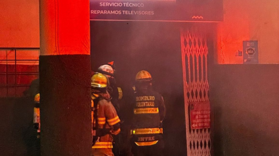 Bomberos apagan el fuego de un incendio en un taller de televisores de Guayaquil, el 13 de enero de 2025.