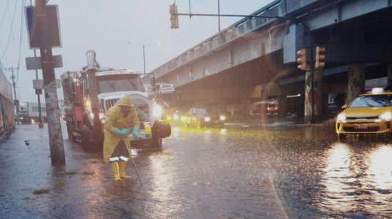 Trabajador limpia calles de Guayaquil en medio de la lluvia