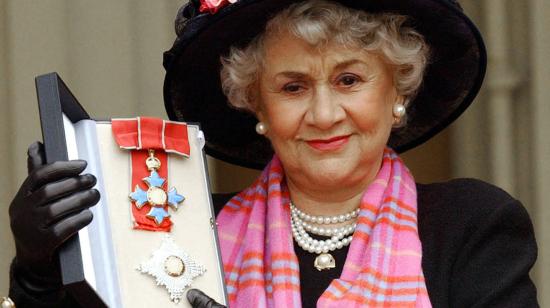 La actriz británica Joan Plowright posa con insignia de Dama otorgada por el Príncipe de Gales en el Palacio de Buckingham, en Londres, en febrero de 2004.