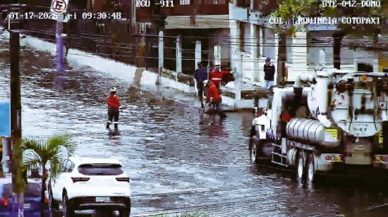 Personal de Interagua realiza limpieza de unas alcantarillas en unas calles de Guayaquil, en medio de intensas precipitaciones, el 17 de enero de 2025.