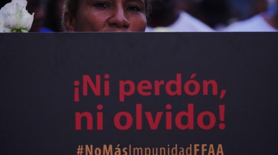 Una mujer porta un cartel para pedir justicia por la desaparición y muerte de los cuatro niños de Las Malvinas, en Guayaquil.