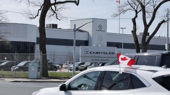 Un carro con una bandera de Canadá pasa junto a una fábrica de autos en Ontario, el 3 de abril de 2025.