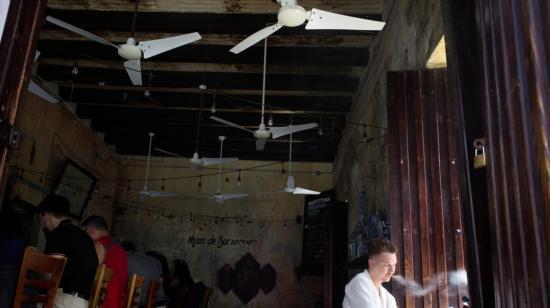 Un hombre fuma en una cafetería sin luz durante un apagón en San Juan, Puerto Rico, 16 de abril de 2025.