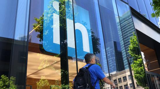 Un trabajador pasa junto a una oficina de la red profesional LinkedIn, en San Francisco, en abril de 2023.
