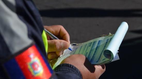 Imagen referencial de un agente de tránsito de la AMT con una citación.