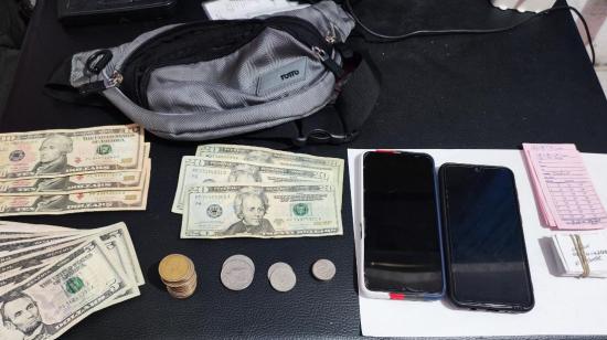Billetes de dólares, monedas, celulares y otros elementos incautados por la Policía en un operativo contra dos ciudadanos presuntamente implicados en el delito de usura, en Morona Santiago. Foto de octubre de 2026, referencial.
