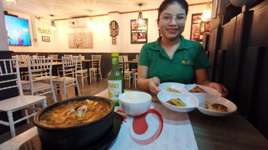 Siwllyn Reyes, de restaurante coreano Momo, junto a un plato de Kimchi jjigae, una de las especialidades del local ubicado en el norte de Guayaquil.