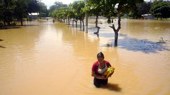 Una mujer camina en medio de una inundación en Balao, cantón de Guayas, el 28 de septiembre de 2026.