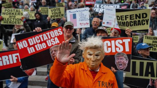Una persona que lleva una máscara del presidente estadounidense Donald Trump y un uniforme de presidiario participa en una manifestación en Nueva York, el 17 de octubre de 2026.