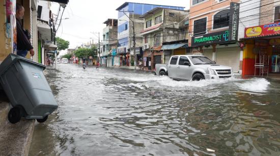 Un carro en una avenida inundada de Sauces 6, norte de Guayaquil, tras las fuertes lluvias del 19 de octubre de 2026.