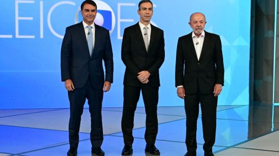 El candidato presidencial derechista brasileño Flavio Bolsonaro, el periodista y moderador del debate Cesar Tralli, y el presidente de Brasil y candidato presidencial Luiz Inácio Lula da Silva posan antes de un debate presidencial previo a la segunda vuelta electoral en Río de Janeiro, Brasil, el 23 de octubre de 2026