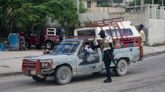 Un policía haitiano revisa los documentos de un conductor el sábado 24 de octubre de 2026, mientras continúa la búsqueda de cuatro militares salvadoreños integrantes de la Fuerza de Supresión de Pandillas desaparecidos tras sufrir una emboscada, en Puerto Príncipe (Haití).