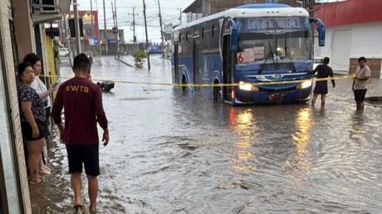Un bus circula por una calle inundada en el barrio Costa Azul, de Manta, tras la intensa lluvia del 26 de octubre de 2026.