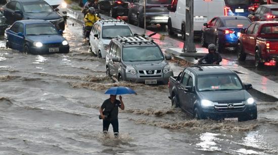 Un hombre camina por aguas anegadas tras fuertes lluvias en el norte de Guayaquil, Ecuador, el 26 de octubre de 2026.