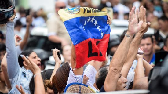 Una mujer sostiene una bandera de Venezuela el 25 de octubre de 2026, durante el regreso de María Corina Machado, en el Santuario Divina Pastora en Barquisimeto (Venezuela).