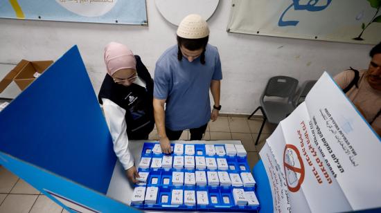 Dos personas eligen las papeletas para votar en un colegio electoral en Umm al-Fahm, Israel, el 27 de octubre de 2026.