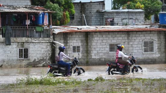 Motociclistas circulan en inundaciones persistentes por hasta cinco días en Machala (El Oro), el 28 de octubre del 2026, en medio de una tregua entre bandas criminales forzada por el clima.
