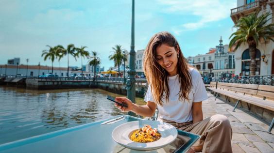 Mujer joven disfrutando de una experiencia gastronómica en un paisaje impresionante.