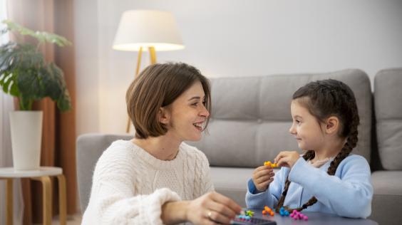 Madre jugando con su hija en la sala de su hogar