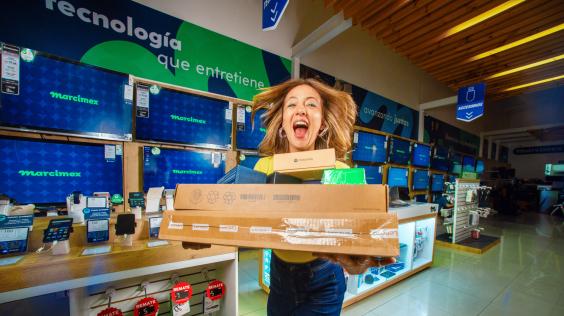 Mujer feliz cargando paquetes en Marcimex