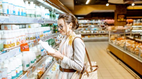 Mujer elige productos de los estantes en el supermercado.