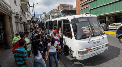 Ciudadanos hacen filas para tomar un bus público en Venezuela. 