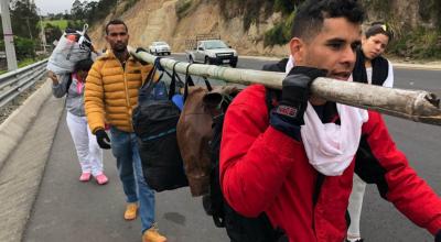 Un grupo de migrante venezolanos camina con su equipaje en la carretara que une a Tulcán con el puente fronterizo de Rumichaca.