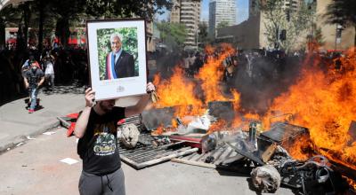 Un manifestante exhibe un cuadro del presidente Sebastián Piñera durante las protestas en Santiago.