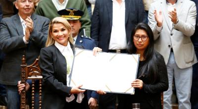 Jeanine Añez, presidenta interina de Bolivia, sostiene la ley para las nuevas elecciones junto con Eva Copa, presidenta del Senado..