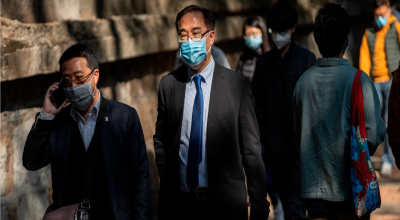 Empleados usando mascarillas se dirigen a sus trabajos en Hong Kong, donde se reporta un fallecido por el coronavirus. 