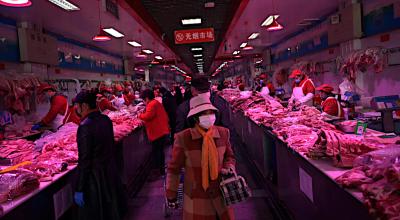 Los clientes de los mercados de Pekín, China, buscan carne de cerdo mientras usan máscaras para evitar posibles contagios de coronavirus.