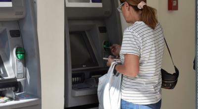 Imagen referencial de una ciudadana haciendo un retiro de un cajero automático de un banco en Quito en 2019.