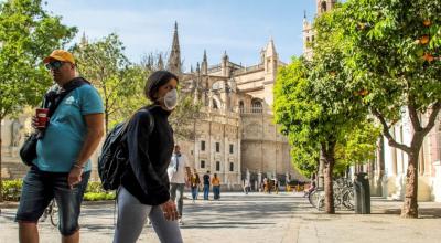 Turistas recorren con mascarilla las calles céntricas de Sevilla con motivo de la crisis del coronavirus.