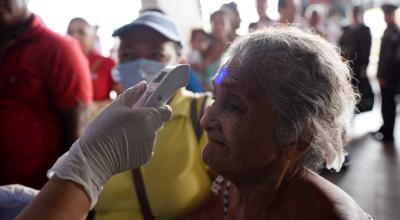 Personal médico controla la temperatura de los pasajeros en la Terminal Terrestre de Guayaquil, el 16 de marzo de 2020.