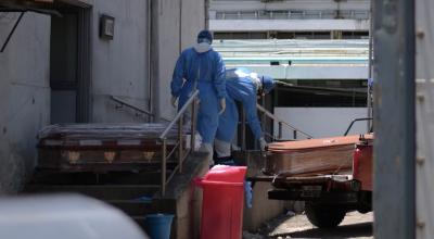 Trabajadores del hospital Teodoro Maldonado Carbo Hospital, en Guayaquil, cargan los ataúdes de dos personas fallecidas por coronavirus, el 3 de abril de 2020.